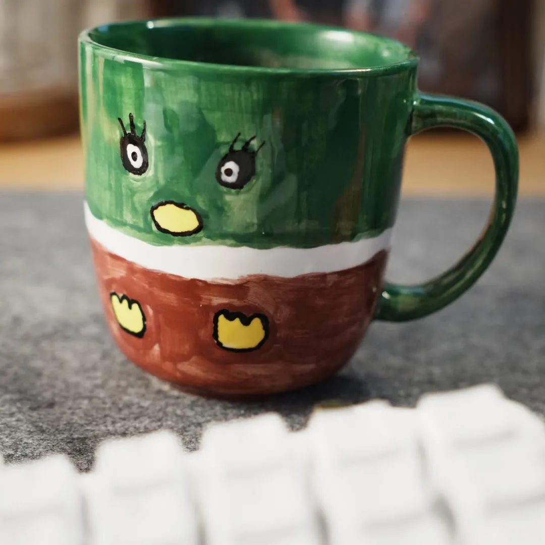 a coffee mug painted like a mallard