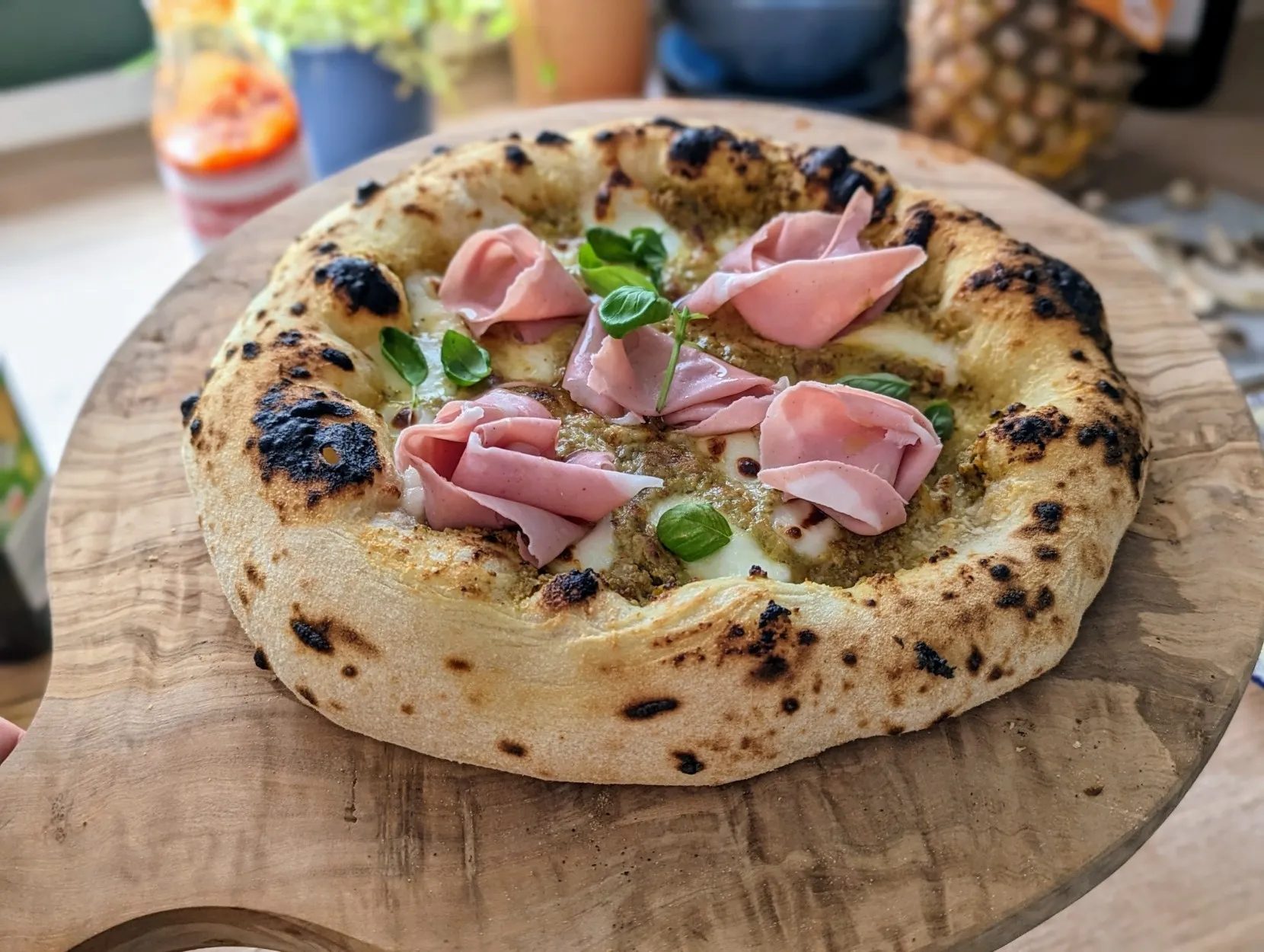 A Neapolitan style pizza with mortadella and a base of pistachio cream.